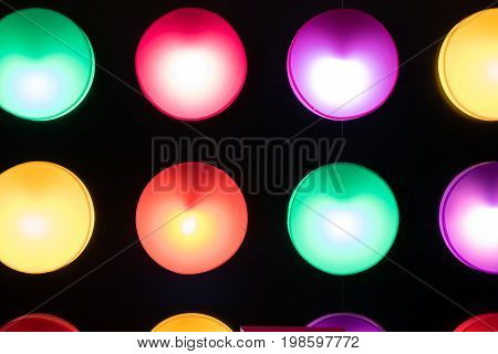 row of colorful circle lamps on black wall for abstract background