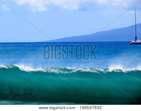 Large Wave Cresting on the shore of Maui with Boat and Island in Background.