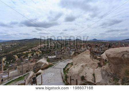 Stairs leading to top fo Uchhisar castle in Cappadocia and view over Cappadocia landscape with villages valleys and rock formations