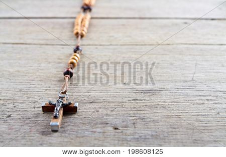 Rosary beads on the old wooden table