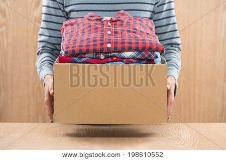 Donation box for poor with clothing in male hands