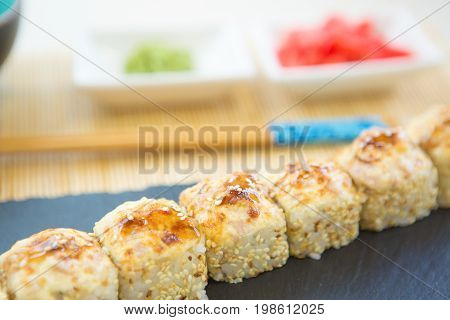 Sushi Rolls On Black Slate Surface. Japanese Food. Hot Fried Sushi Roll