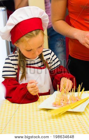 Alchevsk, Ukraine - July 30, 2017: School Cooks For Children. Learn To Cook Pasta With Sausages