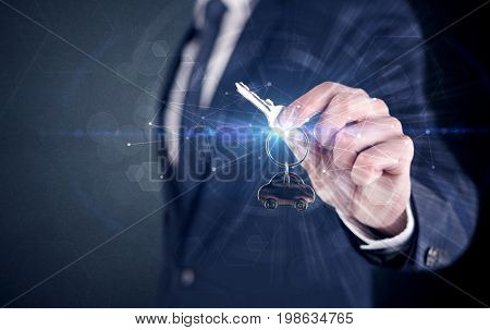 Businessman in suit holding over a key with connection concept around