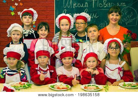 Alchevsk, Ukraine - July 30, 2017: School Cooks For Children. Learn To Cook Pasta With Sausages