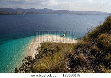 Top View Of Two Boats At The Coast Of A White Sand Beach Surrounded By  Blue Turquoise Colored Ocean