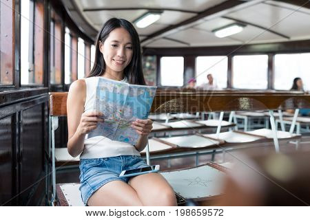 Woman checking location on city map in ferry at Hong Kong