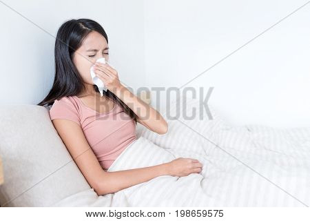 Sick Woman sneezing on bed 