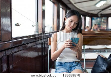 Woman sending sms on mobile phone and taking ferry