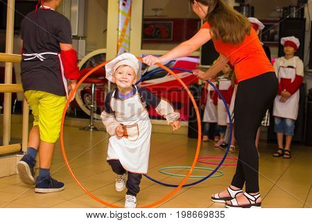 Alchevsk, Ukraine - July 30, 2017: School Cooks For Children. Learn To Cook Pasta With Sausages