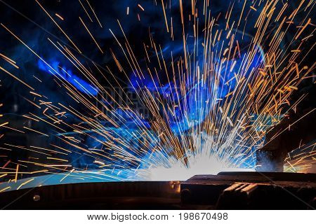 Close-up industrial robot is welding in a car factory