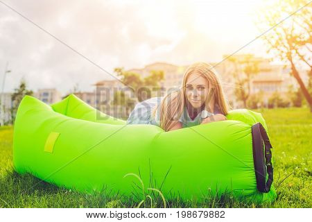 Young Woman Resting On An Air Sofa In The Park.