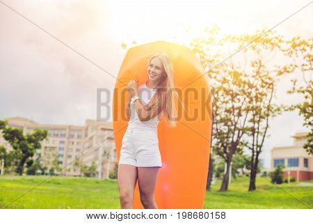 Young Woman Resting On An Air Sofa In The Park.
