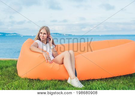 Young Woman Resting On An Air Sofa In The Park.