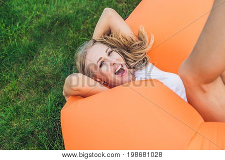 Young Woman Resting On An Air Sofa In The Park.