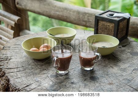 Breakfast hot chocolate for drink with egg and boid rice on the wood table.