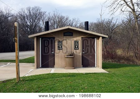 SHOREWOOD, ILLINOIS / UNITED STATES - DECEMBER 6, 2015: An outhouse is available for visitors who need to urinate or defecate in the Hammel Woods Forest Preserve.