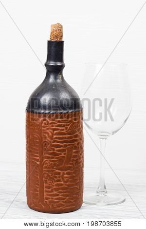 Black bottle of wine and wneglass on the background of the canvas