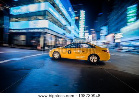 Nyc Yellow Cab Passing Fast At Night In Timesquare Manhattan, New York.