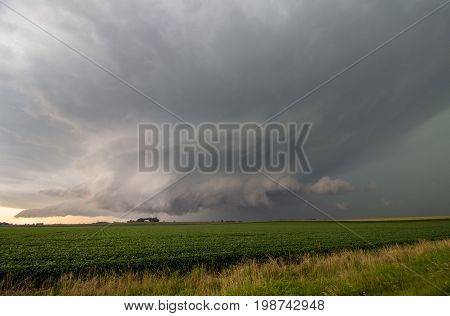 A large supercell thunderstorm hovers over the farmland in Iowa.