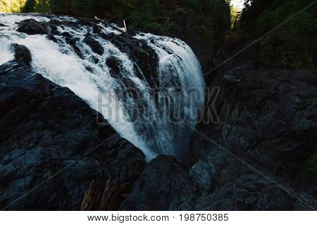 Dark waterscape scenery in forest with waterfalls