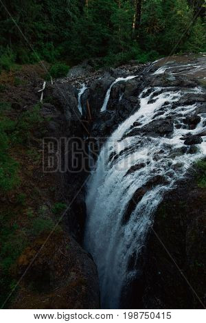 Dark waterscape scenery in forest with waterfalls