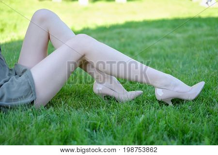 female legs on the grass in the park