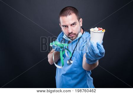 Doctor Holding Pills In Front Of Measuring Tape