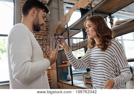 I know nothing. Nice pleasant unhappy man looking at her girlfriend and being surprised while seeing the message