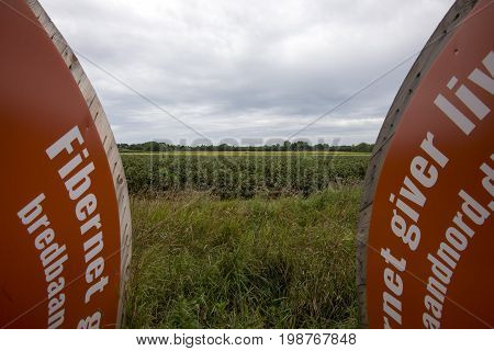 Laesoe Denmark - July 27 2017: Fiber optic cable for fast internet ready to dig down on Laesoe island in Kattegat Sea Denmark.Black currant field in the background.