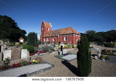 Laesoe Denmark - July 28 2017: Vesteroe red church and cemetery on Laesoe island in Kattegat Sea Denmark.