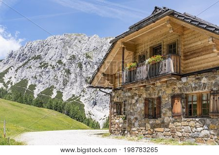 Old stone hut with mountain Gartnerkofel in the background on Nassfeld in Carnic Alps in Austria
