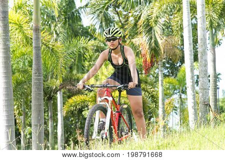 Road bicycle women mountainbiker riding downhill in forest