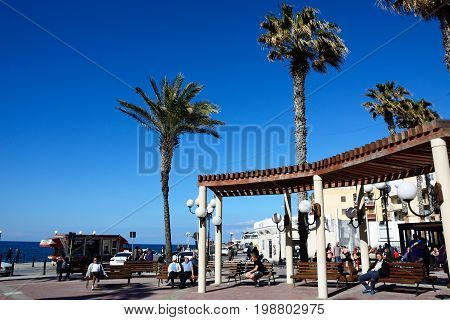 BUGIBBA, MALTA - MARCH 28, 2017 - Tourists relaxing in Bugibba Square during the Springtime Bugibba Malta Europe, March 28, 2017.