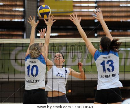 KAPOSVAR, HUNGARY - MARCH 21: Zsuzsanna Czmerk (C) strikes the ball at the Hungarian NB I. League woman volleyball game Kaposvar vs. Eger, March 21, 2010 in Kaposvar, Hungary.