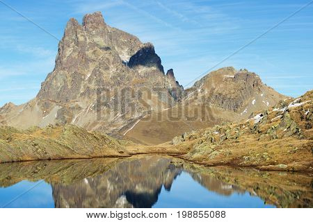 Midi Dossau Peak reflected in a lake. Ossau Valley, Pyrenees National Park, Pyrenees, France.