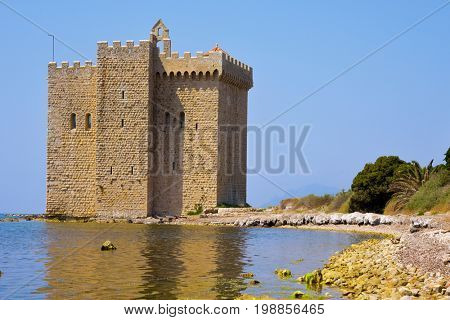 a view of the medieval fortified monastery of the Lerins Abbey in the Saint-Honorat island, France, surrounded by the Mediterranean sea