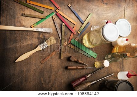 Wood working color samples, brushes  solvents and paint can on old work bench.  Shallow depth of focus.