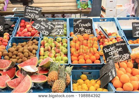 Fresh fruit on a market stalll (text on tags: names and prices of various fruits in Dutch new harvest apples special offer kiwi fresh pompelmoes)