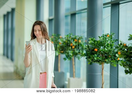 Young woman in international airport walking with her luggage.