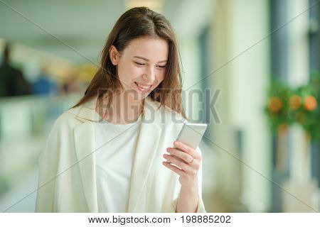 Young woman in international airport walking with her luggage.