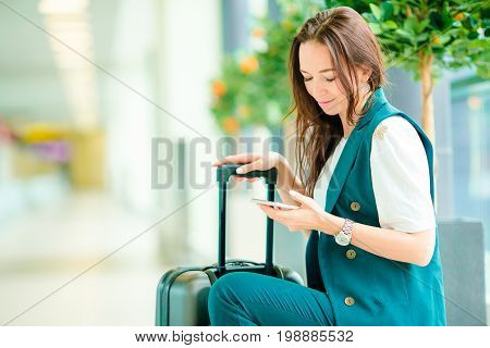 Young woman in international airport walking with her luggage.