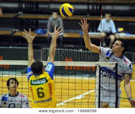 KAPOSVAR, Ungarn - 1 oktober: Akos Hoboth (R) slår bolden ved en Middle Europa League volleyba