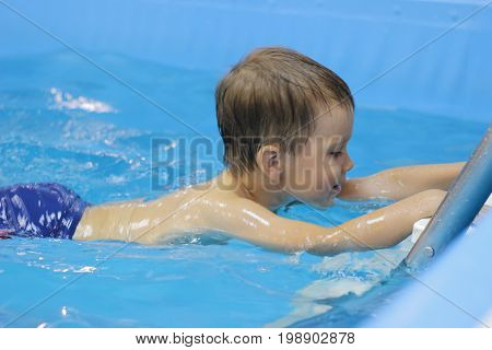 The little boy is practicing in the pool