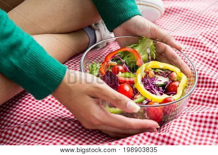 Close-up Of Pretty Girl Hands Holding Fresh Mixed Colorful Fresh Vegetable Salad In Glass Bowl. Vege