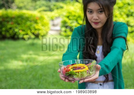 Beautiful Young Woman Holding A Bowl With Salad And Looking At Camera With Smile.  Fresh Vegetable S