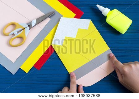 Making greeting card in form of pencil for new school year. Welcome back to school. Children's art project. DIY concept. Step-by-step photo instruction. Step 6. Child glues details of design