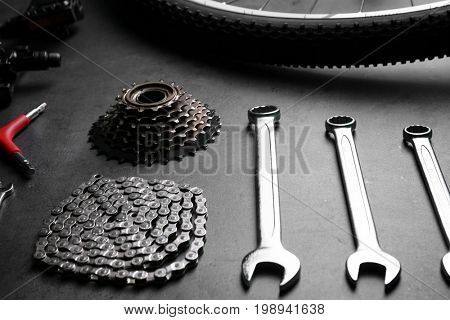 Bicycle parts and repair tools on gray background
