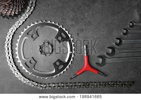 Bicycle parts and repair tools on gray background