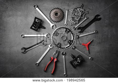 Bicycle parts and repair tools on gray background